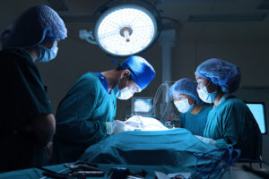 Veterinarian and team performing minimally invasive surgery in an operating room